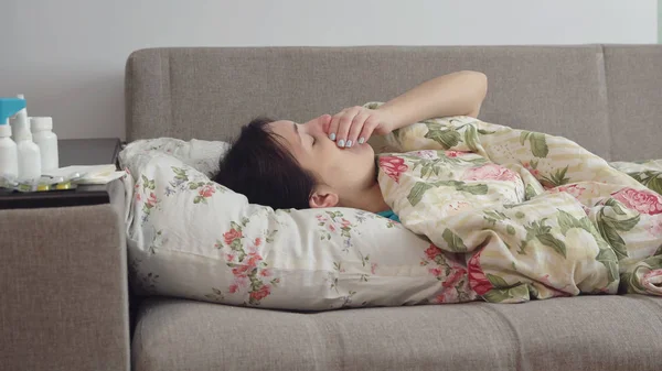 Mujer joven acostada en la cama con tos —  Fotos de Stock