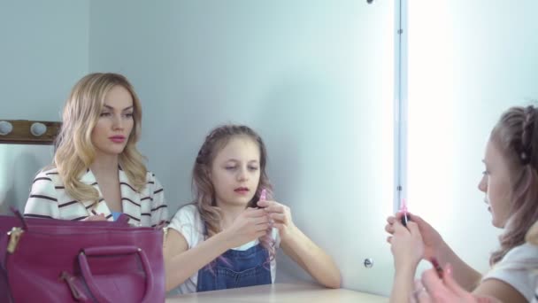 Mor och dotter gör make-up tillsammans. Reflektion i spegeln — Stockvideo