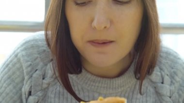 Kadın bir iştahla bir lokanta kafede sosisli sandviç yiyor