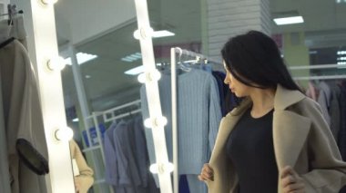 Genç kadın bir giyim mağazası bir ayna önünde ceket ölçme