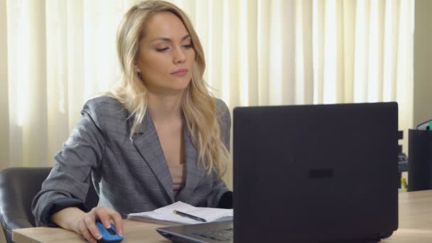 Молодая деловая женщина в костюме работает за компьютером в офисе . — стоковое видео