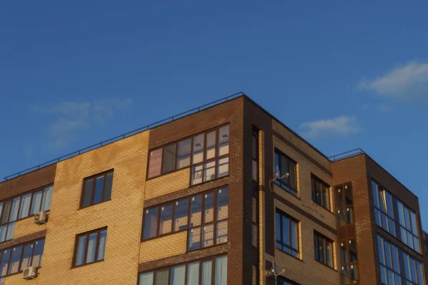 Новый жилой дом с балконами на фоне голубого неба — стоковое фото