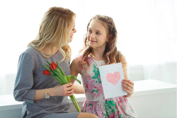 Дочь подарила маме букет тюльпанов и открытку, сделанную собственными руками. Счастливое материнство — стоковое фото