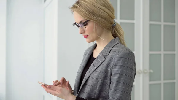 Retrato joven mujer de negocios usando teléfono inteligente que sostiene gadget móvil, sonrisa de chica y mensaje de texto . — Foto de Stock