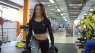 Spor salonunda egzersiz genç esmer kadın. Kalça egzersizleri