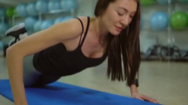 Sağlıklı bir yaşam tarzı kavramı. Genç kadın bir spor salonu mat egzersizleri yapıyor