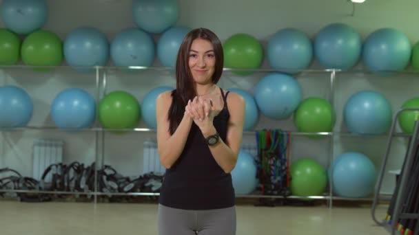 Concept van een gezonde levensstijl. Jonge vrouw warming-up vóór de training in de sportschool doet — Stockvideo