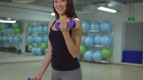 Fitness-konceptet. Unga idrottskvinna träning med hantlar i gymmet — Stockvideo