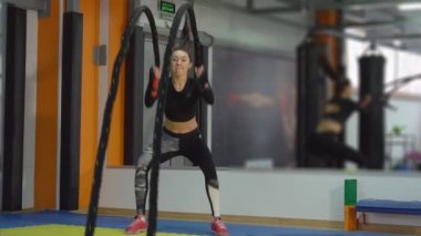 Kardiyo önceliklendirme. Genç kadın ile ipler spor salonunda nişanlı.