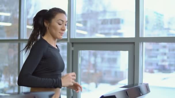 Fitness koncept. Mladá krásná žena na běžícím pásu v posilovně — Stock video