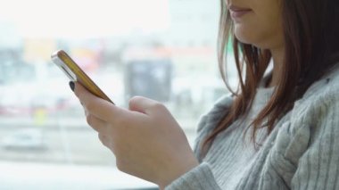 Cam kenarında bir kafede bir telefon olan kadın