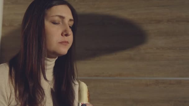 Lunchrast. Ung kvinna äta en rulle i ett café — Stockvideo