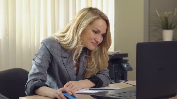 Happy businesswoman in suit works at the computer in office. — Stock Video