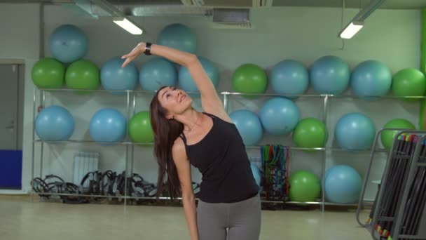 Jonge vrouw doet warming-up vóór de training in de sportschool. Fitness concept — Stockvideo