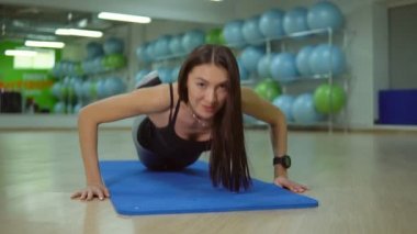 Fitness kavramı. Genç kadın bir spor salonu mat egzersizleri yapıyor