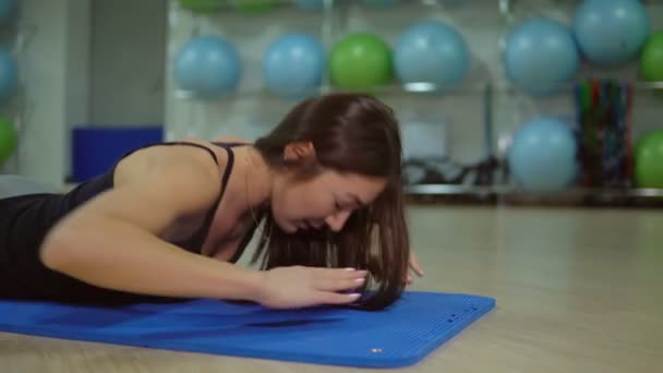 Jonge vrouw doen oefeningen voor de rug op een fitness mat. Het concept van een gezonde levensstijl — Stockvideo