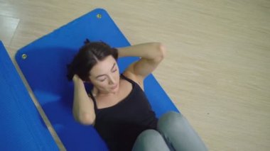 Güzel esmer kadının karın kasları egzersiz yapması. Yukarıdan görüntülemek