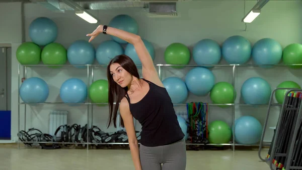 Mladá žena dělá rozcvička před tréninkem v tělocvičně. Koncept zdravého životního stylu — Stock fotografie