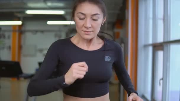 A correr numa esteira. Mulher bonita atlética morena no ginásio — Vídeo de Stock