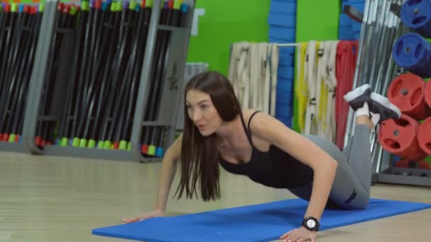 Piękna kobieta robi pompki na matę do ćwiczeń w sali fitness — Wideo stockowe