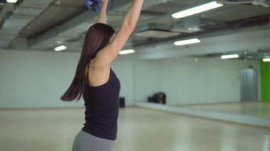 Güzel esmer kadın bir halter ile yapıyor. Fitness kavramı