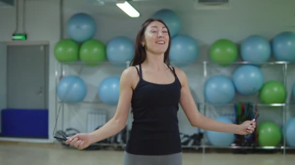 Hermosa mujer saltando la cuerda en el gimnasio. El concepto de un estilo de vida saludable — Vídeos de Stock