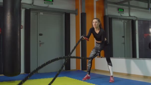 Cardio-Triage. Schöne Frau mit Seilen in der Turnhalle beschäftigt — Stockvideo