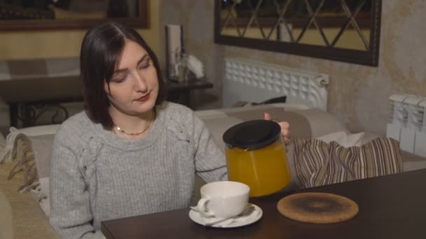 Bruna donna in un caffè versa tè vitaminico — Video Stock