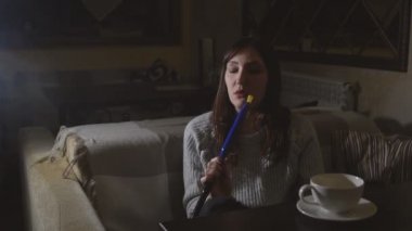 Genç esmer kadın bir kafede bir nargile duman yangınları