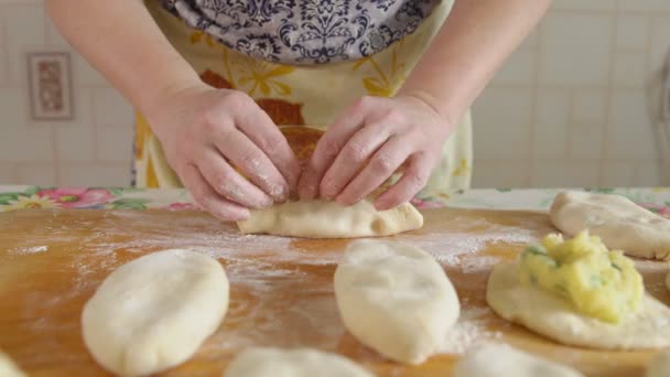 Cocinar pasteles. Mujer pega masa con relleno en el interior — Vídeo de stock