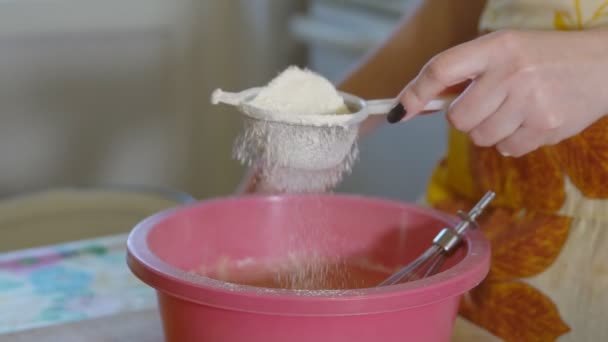 Mulher peneira a farinha através de uma peneira na cozinha — Vídeo de Stock