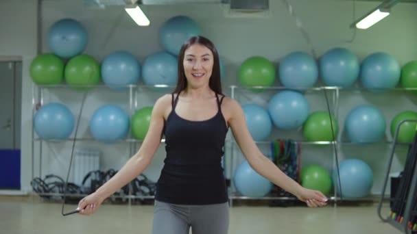 Slow motion of young athletic woman jumping rope in the gym. — Stock Video