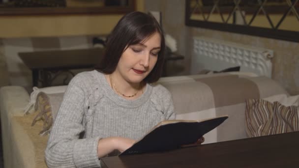 Brunette femme dans un café regarde le menu — Video