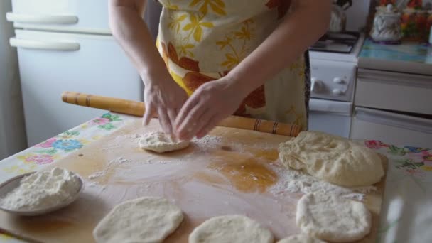 Γυναίκα σε μια ποδιά στην κουζίνα λειτουργεί με μια ζύμη — Αρχείο Βίντεο