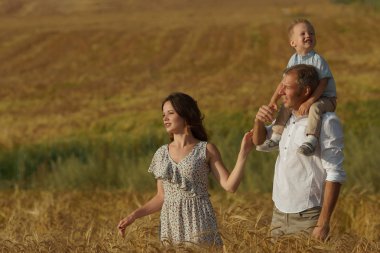 Mutlu anne ve çocuk buğday alanda yürüyüş