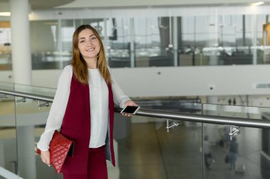 genç kız şık giysileriyle standları ve havaalanında smartphone içinde yazarak.