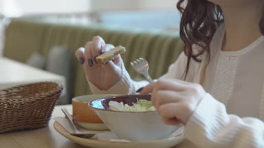 Öğle yemeği molası. Genç bir kadın bir kafede yiyor