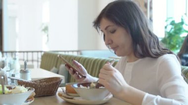 Genç kadın Cafe telefon ile. Öğle yemeği molası