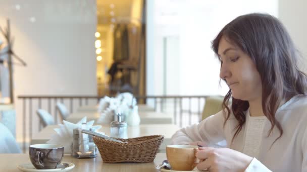 Kaffeepause. junge Frau in einem Café — Stockvideo