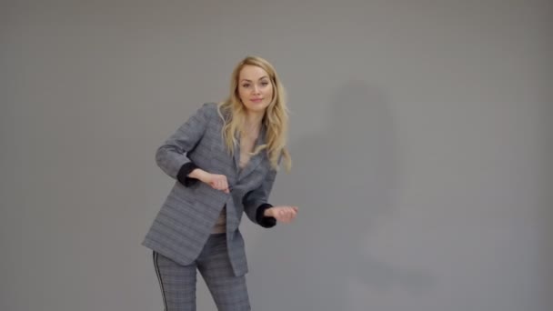 Glada dansare flicka i passar dansande freestyle i office på grå bakgrund. — Stockvideo