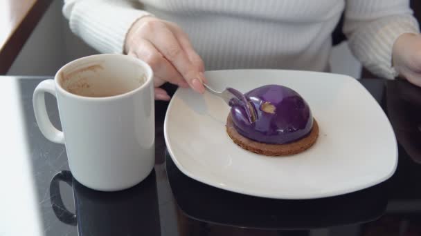 Leckeres Dessert. eine Frau in einem Café trinkt Kaffee mit Kuchen — Stockvideo