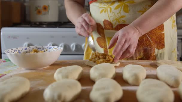 Matlagning. En kvinna sätter en paj fyllning — Stockvideo