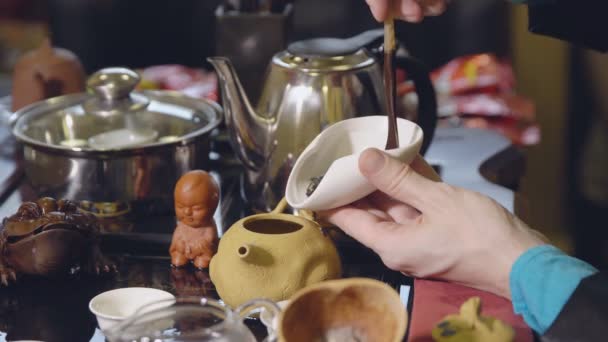 Teezeremonie. der Meister löffelt die grünen Teeblätter mit einem Holzlöffel in den Wasserkocher — Stockvideo