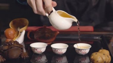 Çay töreni. Master üzerinde beyaz bardak çay dökülen