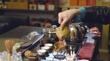 Usta çay yapraklarını suyla doldurur. Çay töreni.