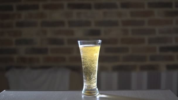Glazen beker gevuld met bier op tafel — Stockvideo