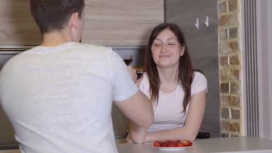 Romantik akşam. Erkek ve kadın bir masada şarap ve çilek ile