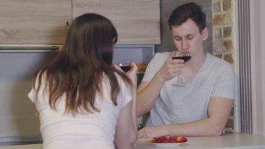 Genç adam ve kadın şarap ve çilek ile bir masada. Romantik akşam