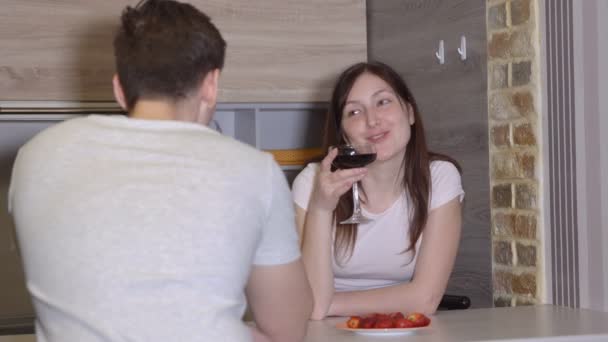 Casal jovem em uma mesa com vinho e morangos. Noite romântica — Vídeo de Stock