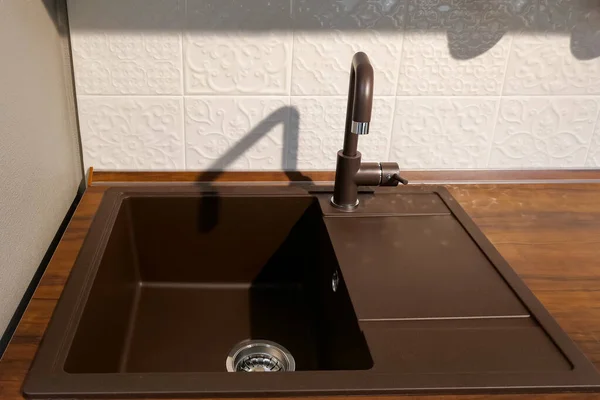 Modern dark brown square sink located on kitchen set surface — Stock Photo, Image